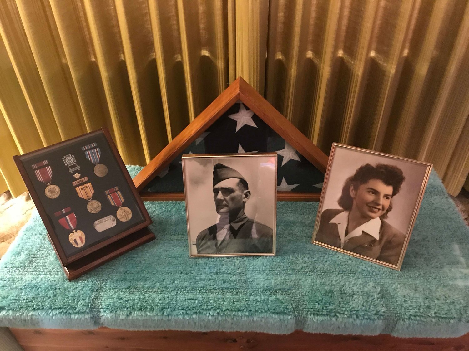 Photos of a young Helen Holloway and her first husband, Merle Foote, with medals from his World War II service, on display in her Centralia home in 2018.